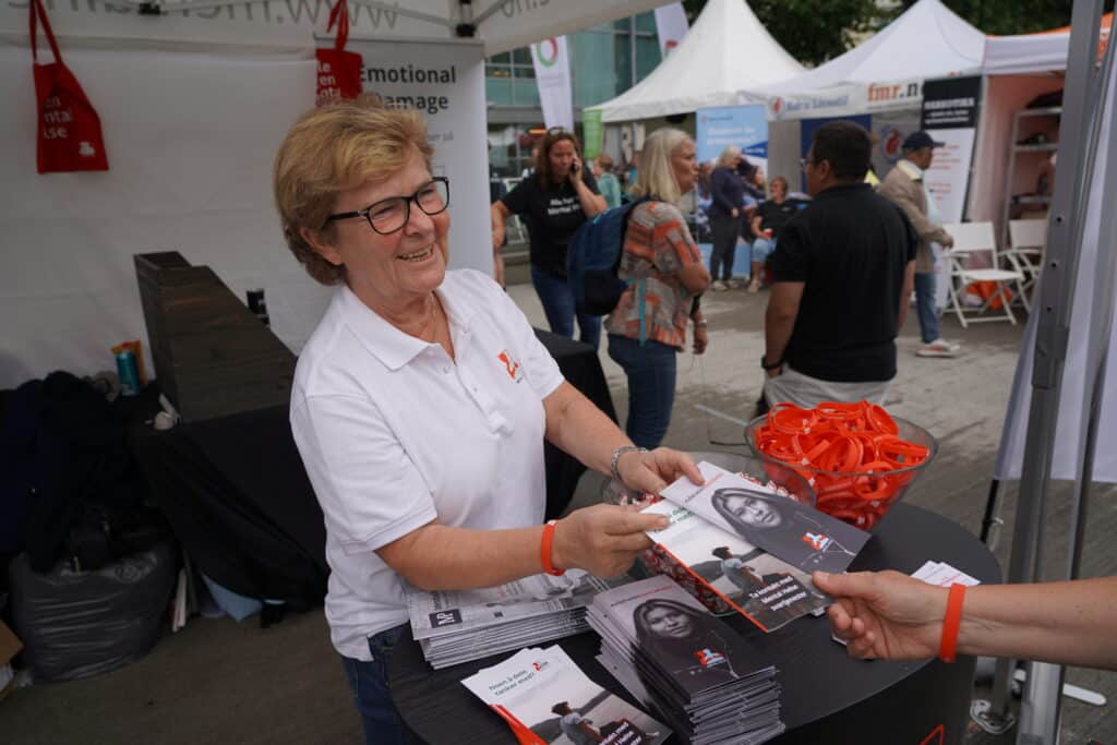 Aslaug deler ut brosjyrer på stand under Arendalsuka 2024