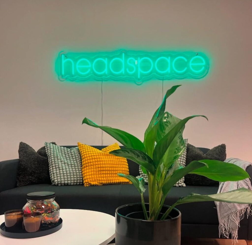 Neonskilt som viser Headspace på veggen inne på Sagene samfunnshus