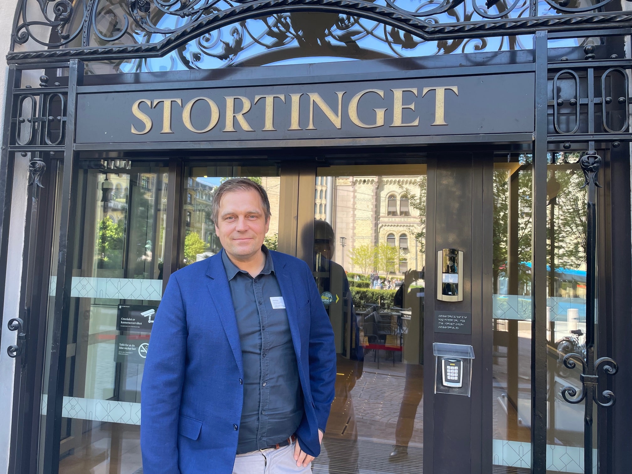 En mann som står foran inngangen til Stortinget