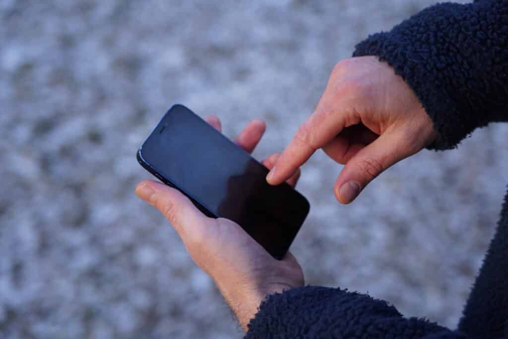 Hånd holder en telefon.