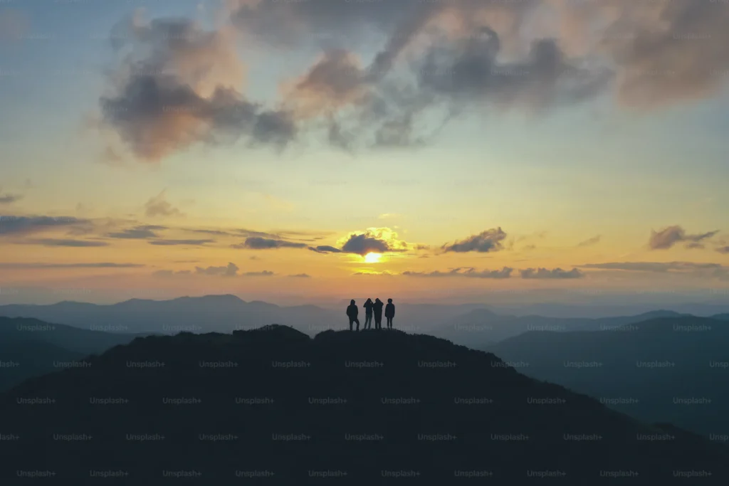 4 mennesker på en topp med solnedgang
