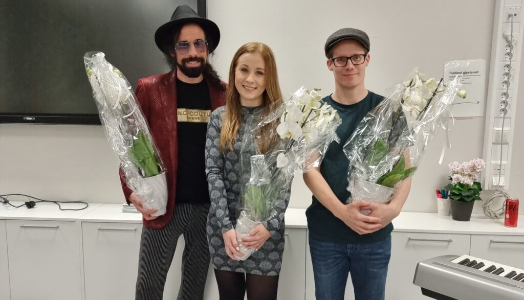 tre personer som får blomst som takk for å ha deltatt på verdensdagen for psykisk helse i Sarpsborg